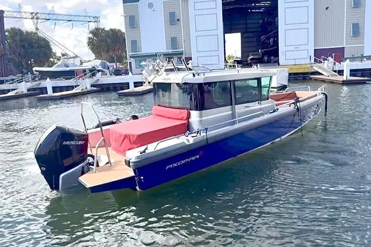 Slide: The Image of 2019 Axopar 28 Cabin boat docked at marina with Mercury engine. - 7