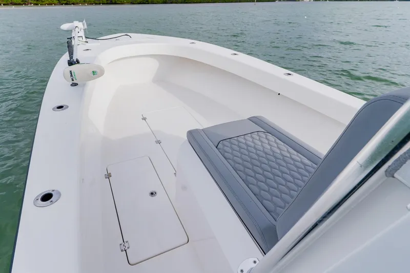 Slide: The Image of 2024 Orion 29CC boat interior with cushioned seating and storage compartments on the water. - 13