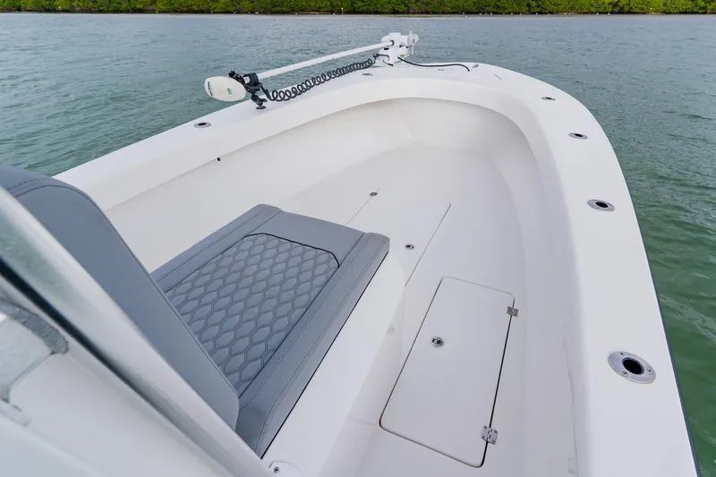 Slide: The Image of 2024 Orion 29CC boat interior with seating and storage, on calm water. - 14