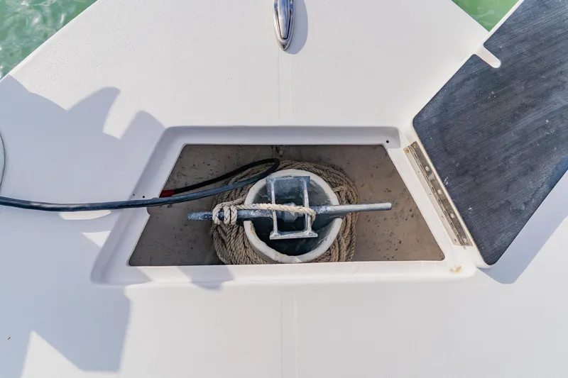 Slide: The Image of Anchor storage compartment on 2024 Orion 29CC boat, featuring coiled rope and anchor. - 17