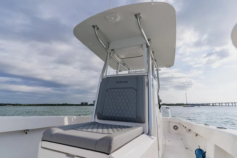 Slide: The Image of 2024 Orion 29CC boat with sleek seating, cruising on open water under cloudy skies. - 21