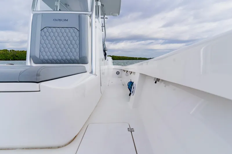 Slide: The Image of 2024 Orion 29CC boat interior with sleek seating and modern design on a calm water backdrop. - 29