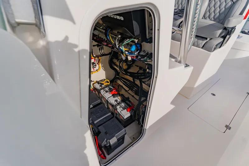 Slide: The Image of Interior view of 2024 Orion 29CC boat's battery compartment with wiring and seating. - 31