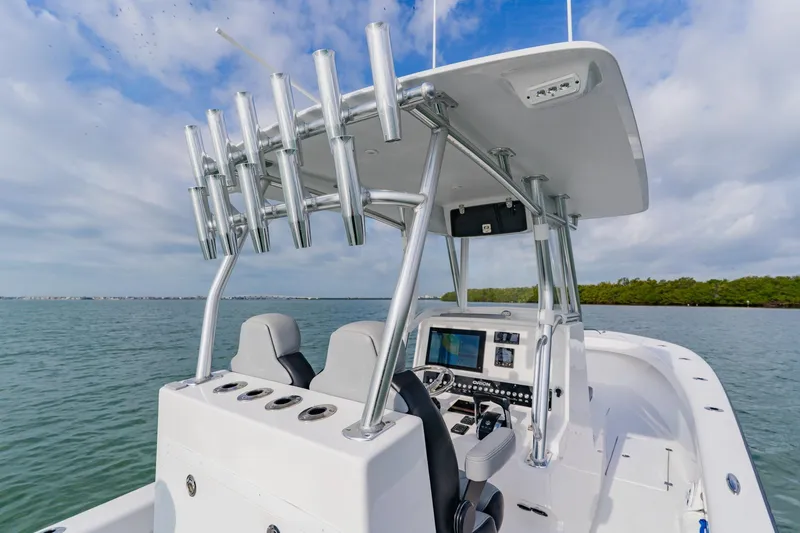 Slide: The Image of 2024 Orion 29CC boat interior with advanced navigation system and rod holders on open water. - 34