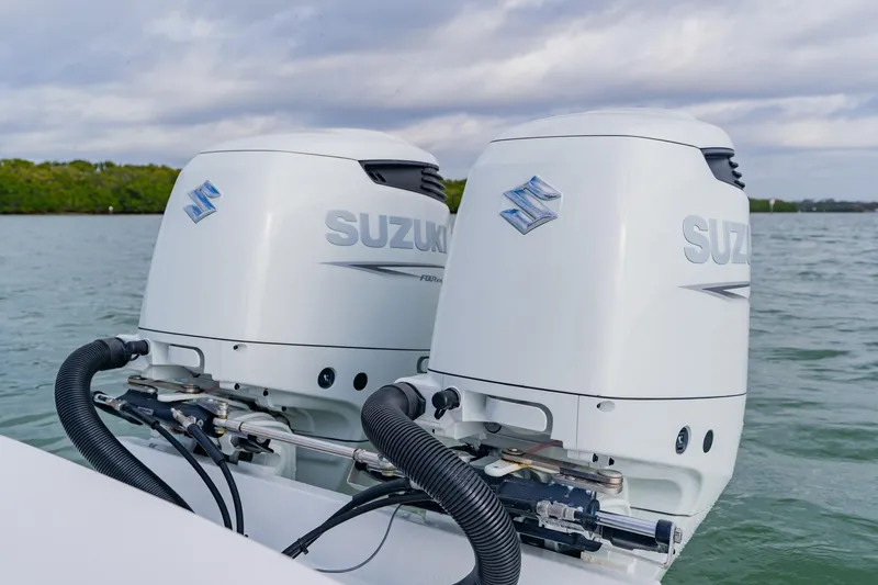 Slide: The Image of Twin Suzuki outboard motors on a 2024 Orion 29CC boat, cruising on a calm lake. - 45