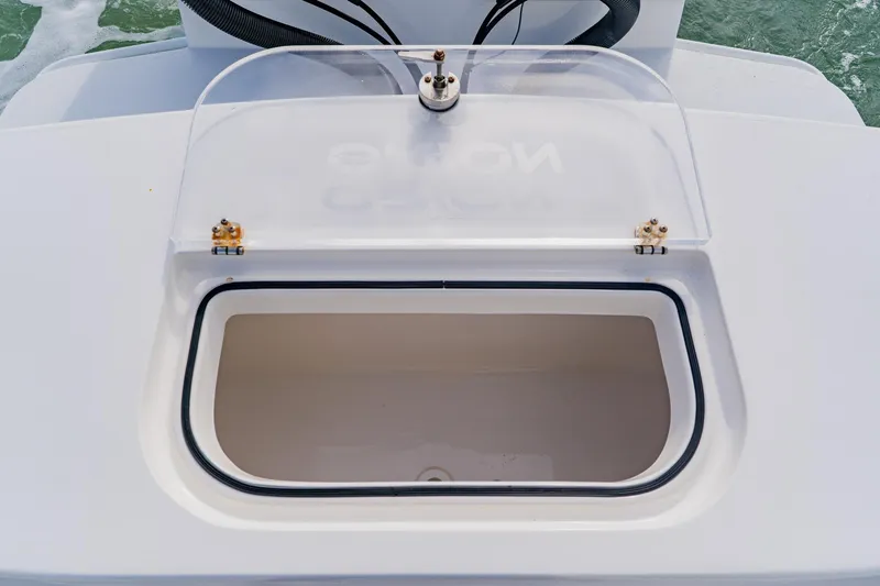 Slide: The Image of Open storage compartment on 2024 Orion 29CC boat, featuring a clear lid and secure seal. - 49