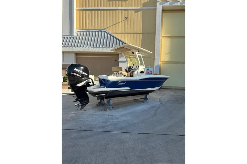 Slide: The Image of 2018 Scout 225 XSF boat with Mercury engine, parked outdoors on a stand. - 1