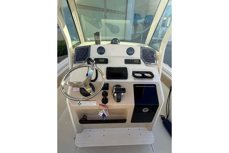 Slide: The Image of 2018 Scout 225 XSF boat dashboard with steering wheel and control panel. - 12