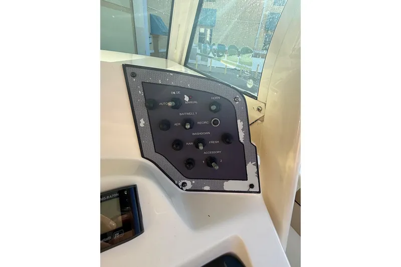 Slide: The Image of Control panel of a 2018 Scout 225 XSF boat with various switches. - 14