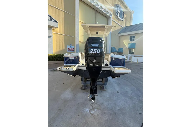 Slide: The Image of 2018 Scout 225 XSF boat with a 250 horsepower outboard motor, docked outdoors. - 2