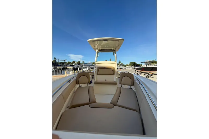 Slide: The Image of 2018 Scout 225 XSF boat interior with seating, docked under clear blue sky. - 24