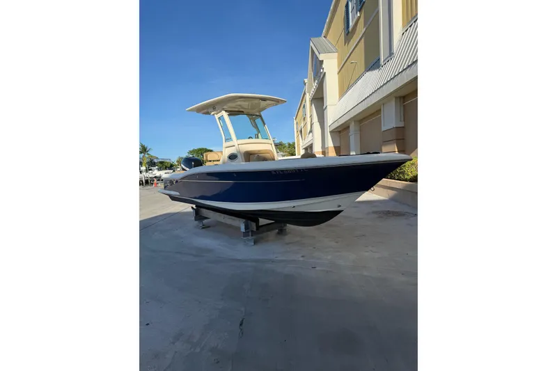 Slide: The Image of 2018 Scout 225 XSF boat displayed outdoors near a building. - 5