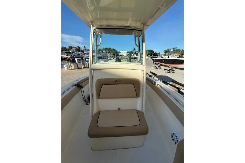 Slide: The Image of 2018 Scout 225 XSF boat interior with tan seating and clear blue sky. - 7