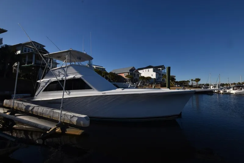 The Image of 1990 Ocean Yachts 48 Super Sport docked at a marina under clear blue skies. - 1