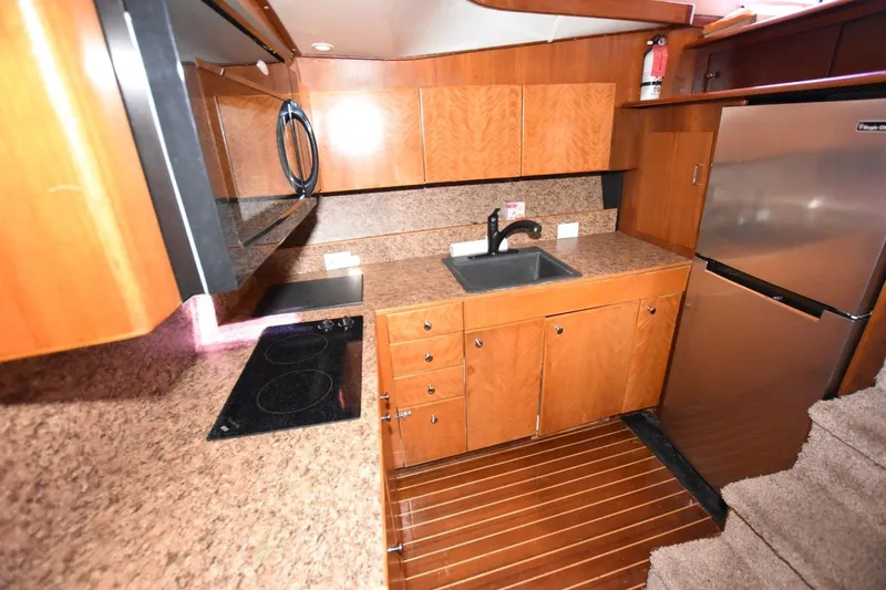 Slide: The Image of 1990 Ocean Yachts 48 Super Sport kitchen with wood cabinets and modern appliances. - 15