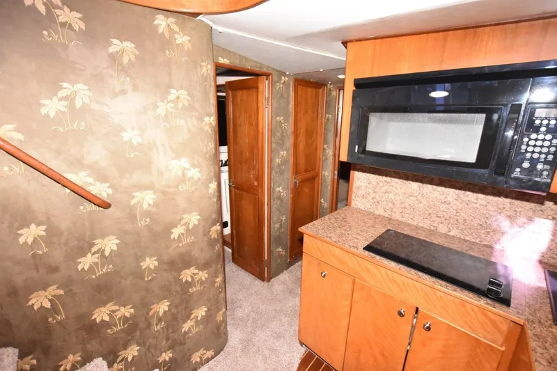 Slide: The Image of Interior of 1990 Ocean Yachts 48 Super Sport with kitchen and palm-patterned walls. - 17