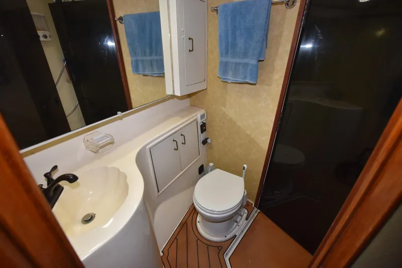 Slide: The Image of Bathroom interior of 1990 Ocean Yachts 48 Super Sport with sink, toilet, and storage. - 19