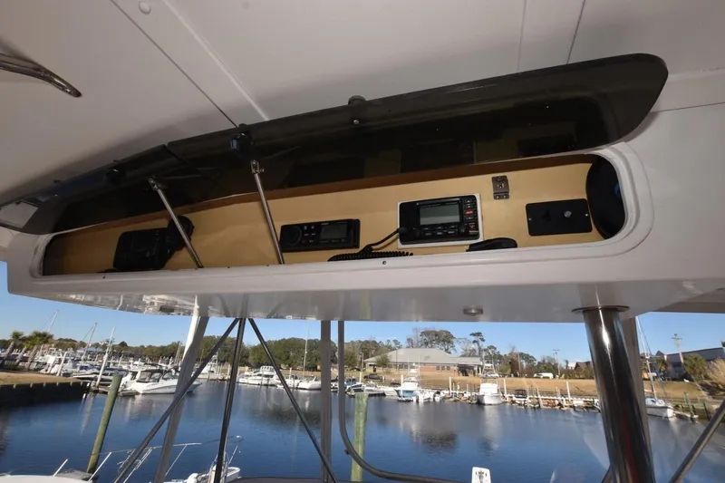 Slide: The Image of 1990 Ocean Yachts 48 Super Sport electronics panel with marina view in background. - 5