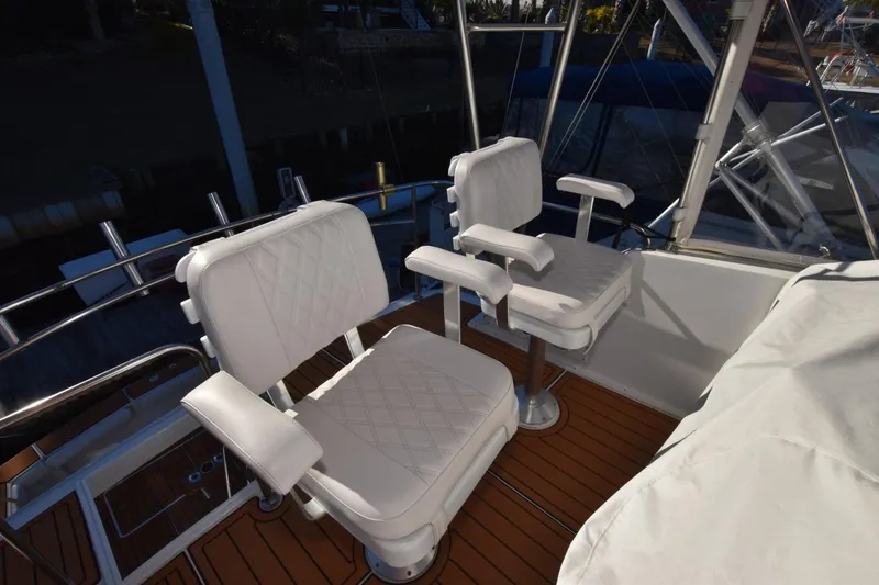 Slide: The Image of Two white cushioned chairs on 1990 Ocean Yachts 48 Super Sport deck. - 6