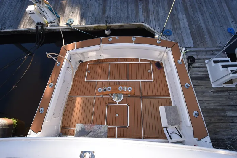 Slide: The Image of 1990 Ocean Yachts 48 Super Sport deck with teak flooring, docked at marina. - 9
