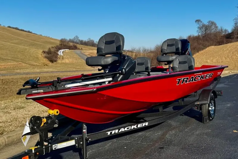 Slide: The Image of 2026 Tracker Pro Team 175 Crappie Edition boat, red, parked on a trailer in a rural setting. - 4