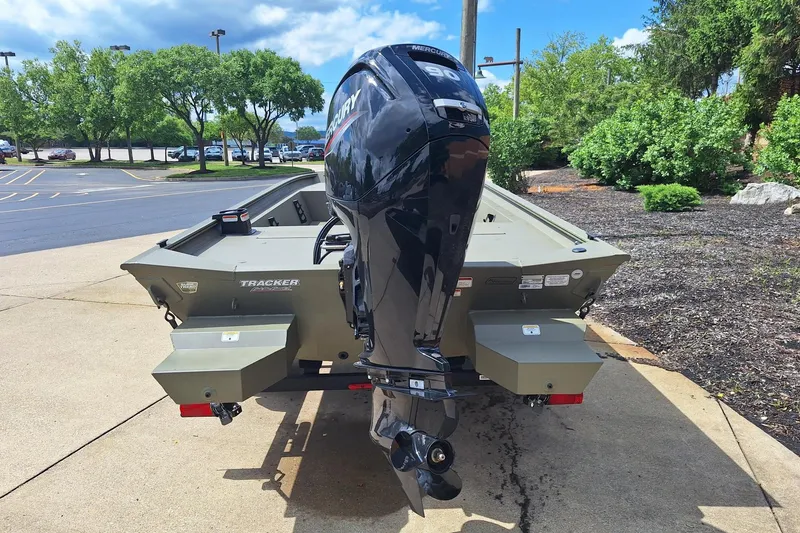Slide: The Image of 2026 Tracker Grizzly 1860 CC boat with Mercury outboard motor, parked outdoors. - 3