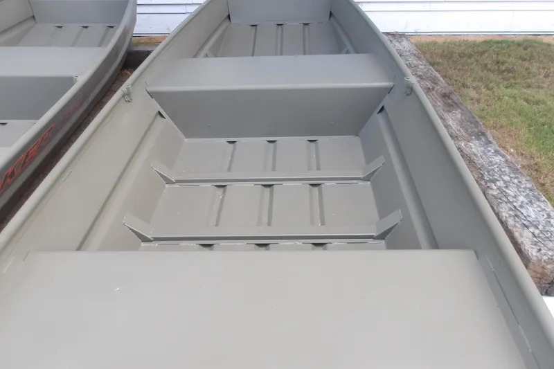 Slide: The Image of 2026 Tracker Grizzly 12 Jon boat interior with bench seating and storage compartments. - 3