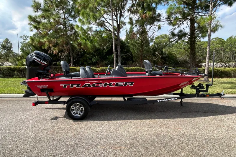 The Image of 2026 Tracker Pro Team 175 boat in vibrant red on a trailer, parked outdoors. - 0