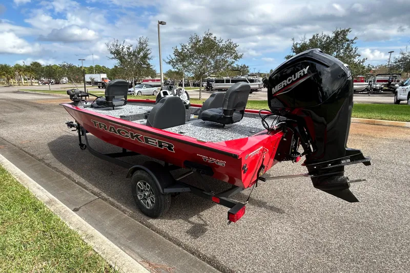 Slide: The Image of 2026 Tracker Pro Team 175 boat with Mercury engine on a trailer, parked outdoors. - 3