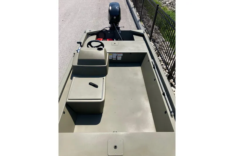 Slide: The Image of 2026 Tracker Grizzly 1648 SC boat interior with steering console and outboard motor. - 7