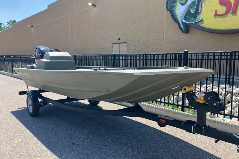 Slide: The Image of 2026 Tracker Grizzly 1648 SC boat on trailer, parked outdoors near a building. - 2