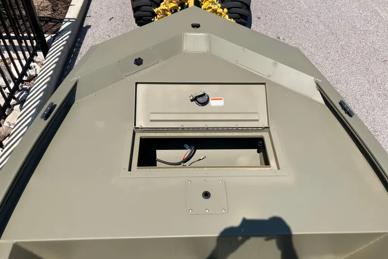 Slide: The Image of 2026 Tracker Grizzly 1648 SC boat deck with storage compartment, outdoors. - 5