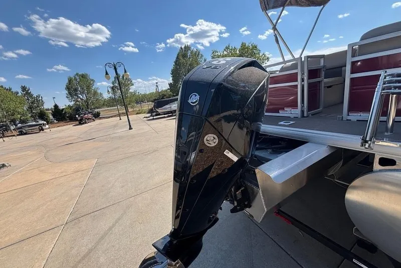 Slide: The Image of 2026 Sun Tracker Party Barge 22 RF XP3 with powerful outboard motor in sunny outdoor setting. - 13