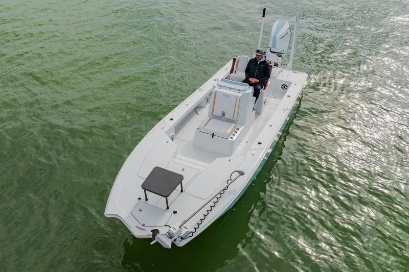 Slide: The Image of 2026 Broadwater 25 Bay Cat boat on calm green water, aerial view. - 11