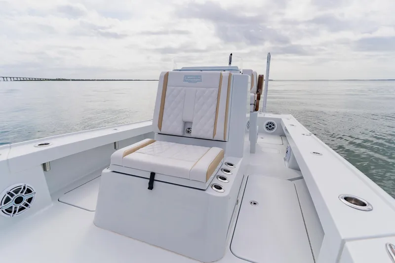 Slide: The Image of 2026 Broadwater 25 Bay Cat boat interior with cushioned seating on calm water. - 22