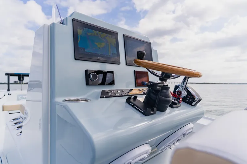 Slide: The Image of Control panel of 2026 Broadwater 25 Bay Cat boat with navigation screens and steering wheel. - 28