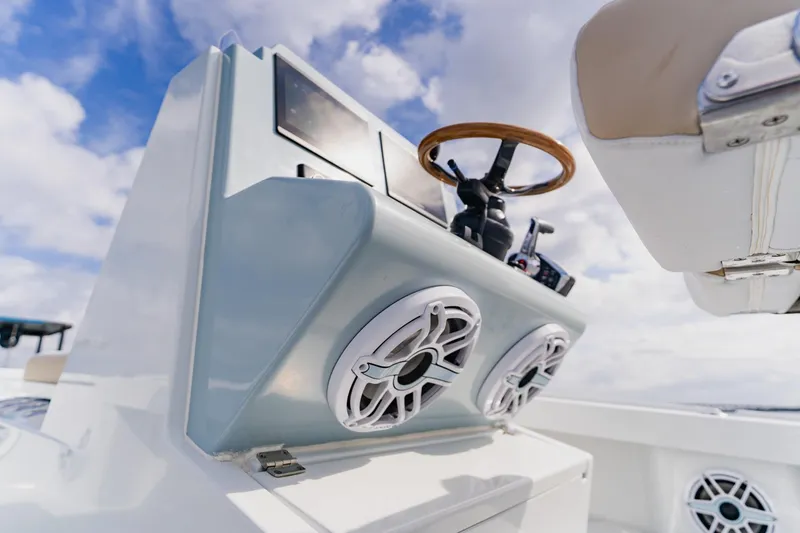 Slide: The Image of 2026 Broadwater 25 Bay Cat boat dashboard with speakers and steering wheel. - 29
