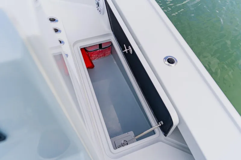 Slide: The Image of Open storage compartment on 2026 Broadwater 25 Bay Cat boat, near water. - 31