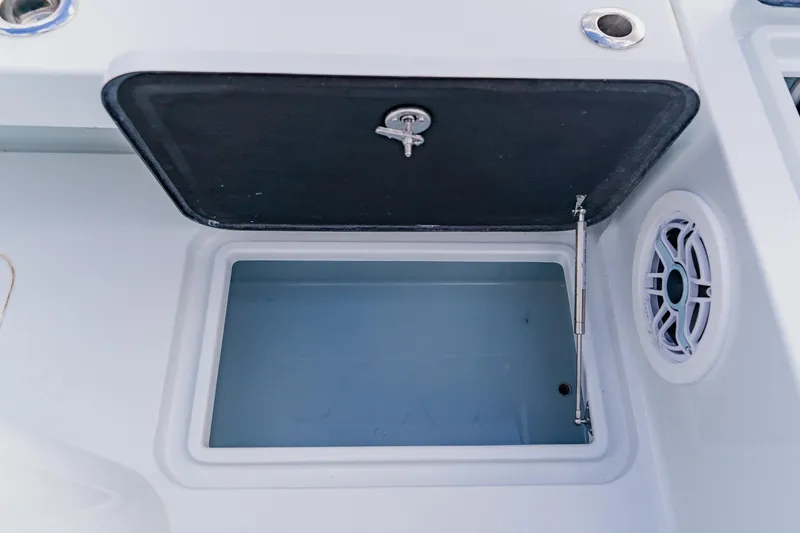 Slide: The Image of Open storage compartment on 2026 Broadwater 25 Bay Cat boat with speaker detail. - 38
