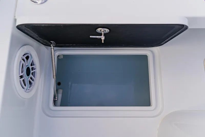 Slide: The Image of Livewell compartment on 2026 Broadwater 25 Bay Cat boat, featuring a speaker and secure lid. - 41