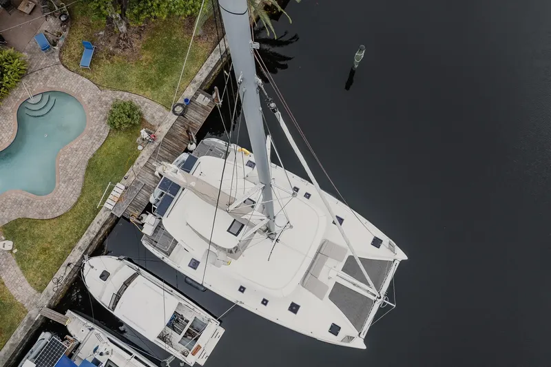 Slide: The Image of Aerial view of 2022 Lagoon 46 catamaran docked near a pool and garden. - 108