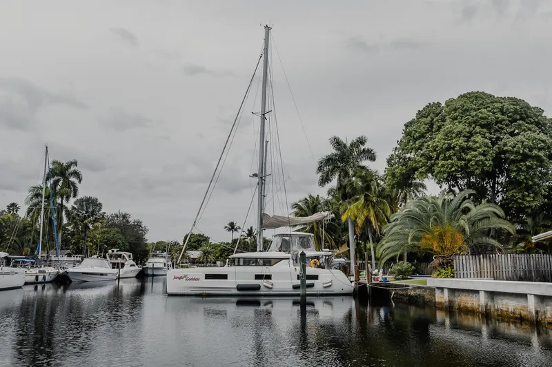 Slide: The Image of 2022 Lagoon 46 catamaran docked in a tropical marina setting. - 109