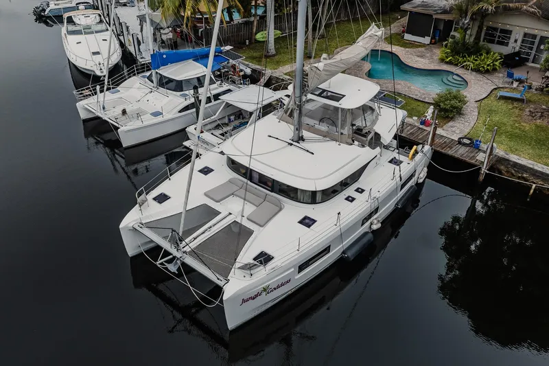 Slide: The Image of 2022 Lagoon 46 catamaran docked by a poolside, showcasing modern design and spacious deck. - 119