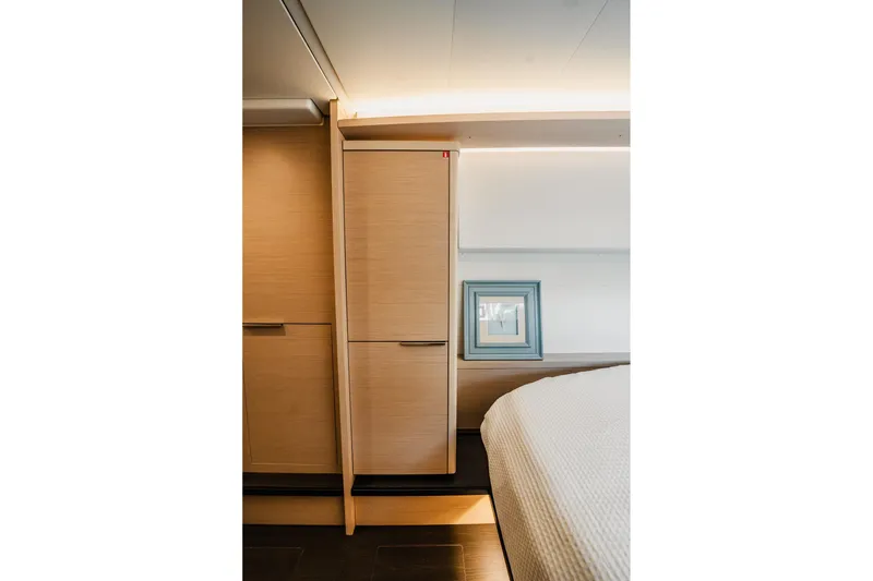 Slide: The Image of Interior of 2022 Lagoon 46 yacht, featuring modern wood cabinetry and soft lighting. - 120