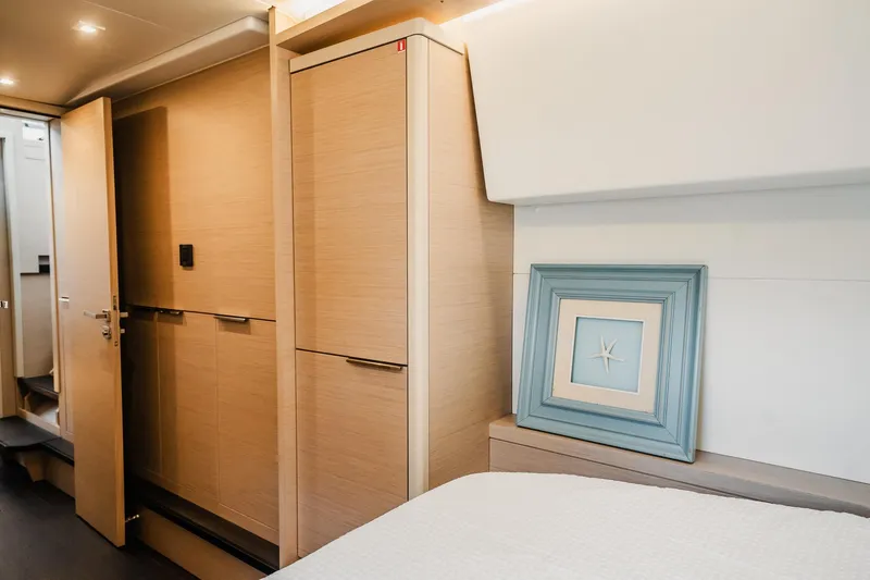 Slide: The Image of Interior of 2022 Lagoon 46 yacht cabin with modern wood finish and starfish artwork. - 135