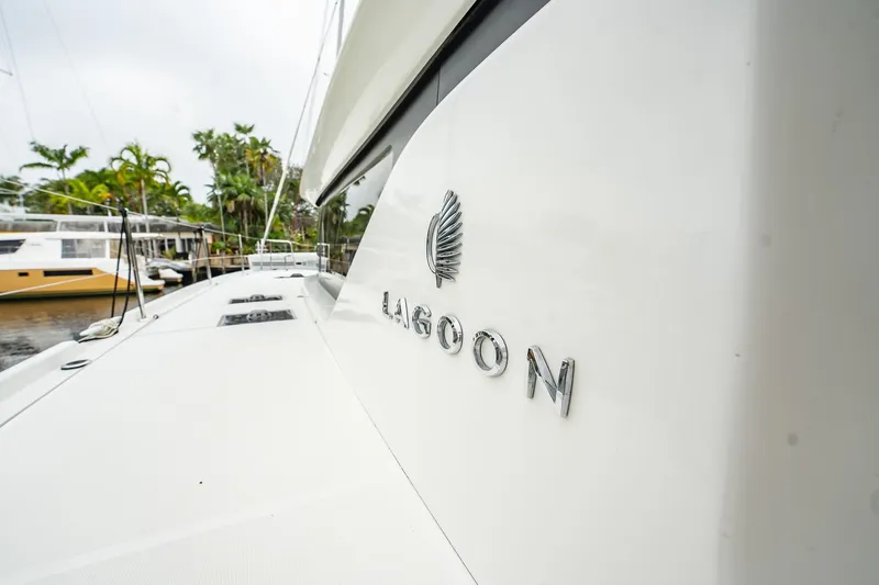 Slide: The Image of 2022 Lagoon 46 catamaran docked, showcasing sleek design and branding. - 136