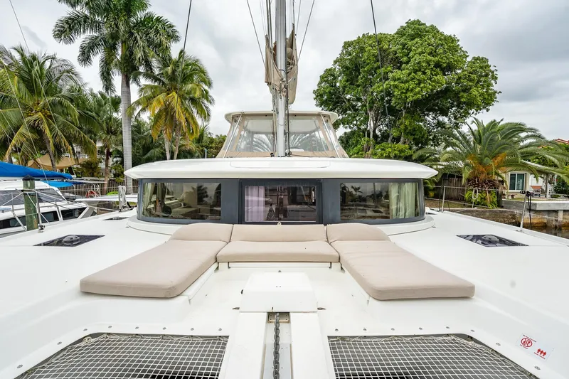 Slide: The Image of 2022 Lagoon 46 catamaran with sunbathing area, surrounded by tropical palm trees. - 139