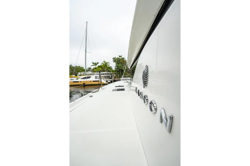 Slide: The Image of 2022 Lagoon 46 catamaran docked, showcasing sleek design and branding. - 149