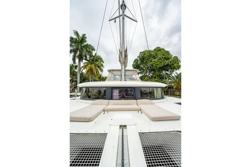 Slide: The Image of 2022 Lagoon 46 catamaran with sunbathing area, surrounded by tropical trees. - 156