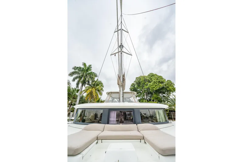 Slide: The Image of 2022 Lagoon 46 catamaran with spacious deck and tropical backdrop. - 161